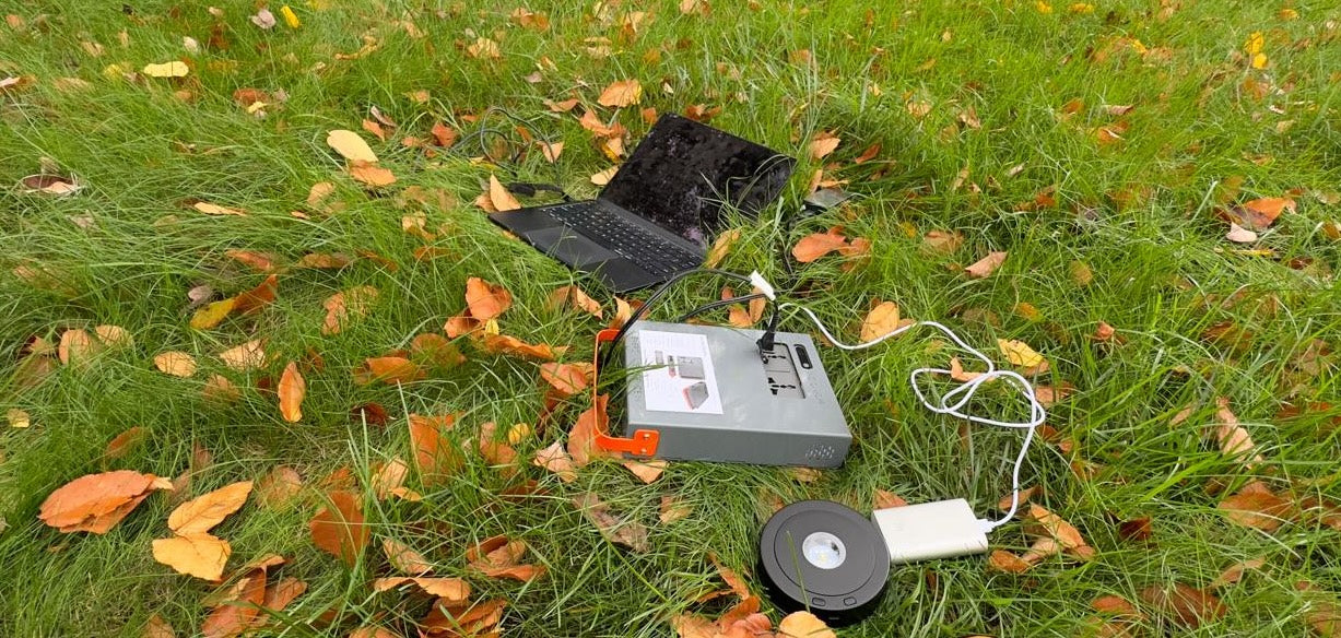 Energy Intelligence Power Station powering a laptop and powerbank outdoors. Energy Intelligence power Station 200 in the wilds