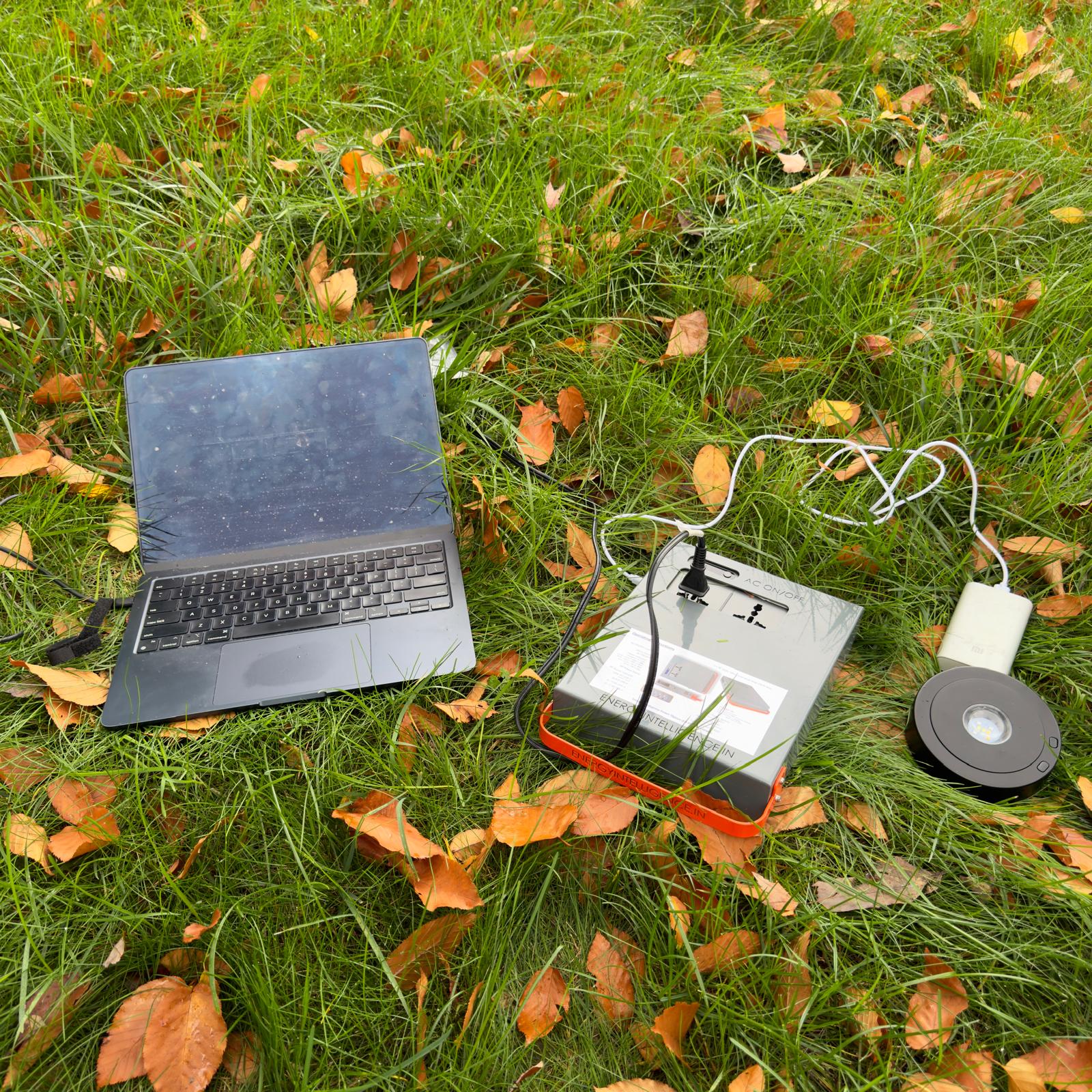 Energy Intelligence Power Station powering a laptop and powerbank outdoors. Energy Intelligence power Station 200 in the wilds