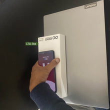 Load image into Gallery viewer, Picture of Energy Intelligence Laptop Powerbank shown stacked on top of a Lenovo laptop and a mobile phone to show relative size of laptop powerbank. Also being held in a single hand to show the portability of the device.
